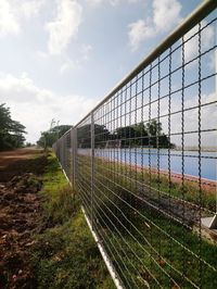 Fence on field against sky