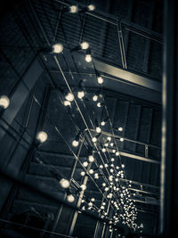 Low angle view of illuminated pendant lights hanging on ceiling in building