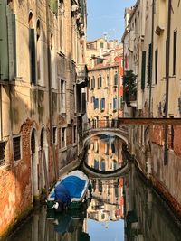 Boats in canal amidst buildings in city
