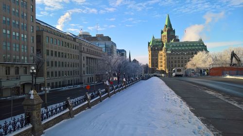 Buildings in city against sky during winter