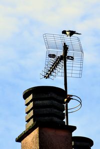 Low angle view of communications tower against sky