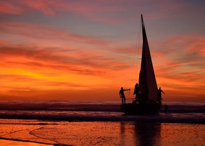 Silhouette ship in sea against sky during sunset