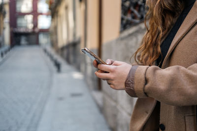 Midsection of woman using mobile phone
