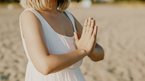 Rear view of young woman standing at beach