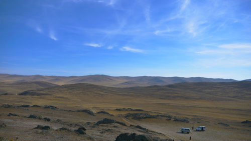 Scenic view of landscape and mountains against blue sky