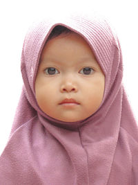 Close-up portrait of innocent girl against white background 