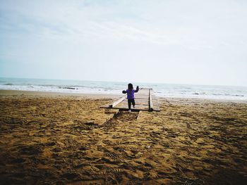 Girl running on pier at beach