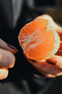 Midsection of person holding orange slice