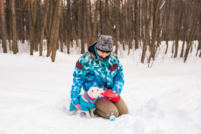Full length of child sitting on snow covered land