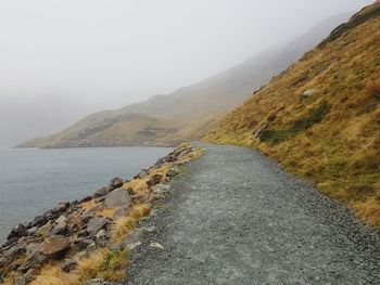 Scenic view of road by mountains against sky in snowdonia united kingdom