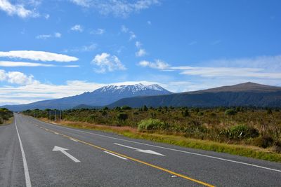 Road by mountains against sky