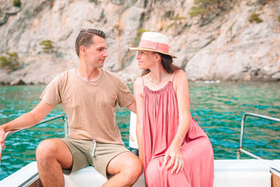 Couple sitting ob boat in sea