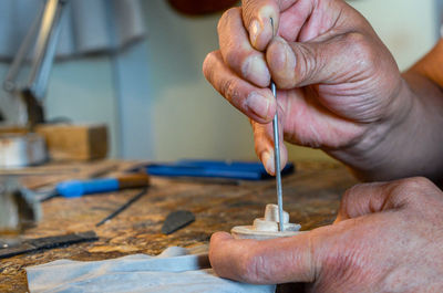 Violin maker luthier hand working a new violin scroll