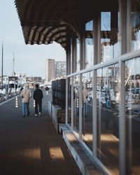 Rear view of men walking on footpath