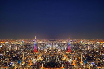 High angle view of illuminated cityscape against clear sky at night