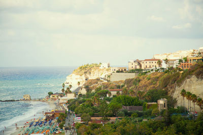 High angle view of townscape by sea against sky