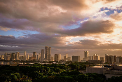 Buildings in city against cloudy sky