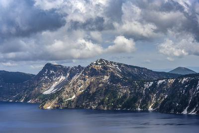 Scenic view of snowcapped mountains by sea against sky