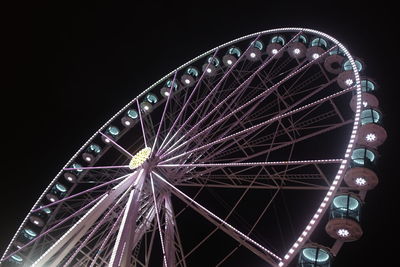 Low angle view of illuminated ferris wheel against sky at night