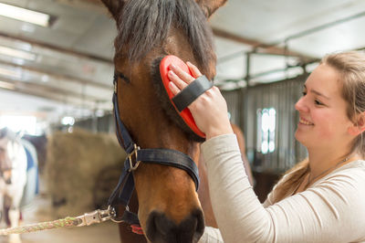 Close-up of young woman with horse