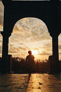 Rear view of silhouette man standing against sky during sunset