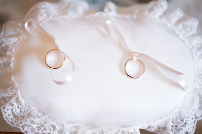 High angle view of wedding rings on white pillow