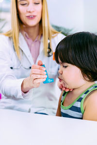 Female doctor examining cute girl in hospital