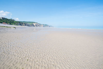Scenic view of beach against blue sky