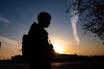 Silhouette man standing against sky during sunset