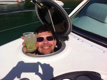 High angle view of happy man holding drink while looking through boat window