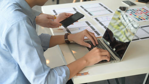 Midsection of man using mobile phone