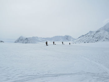 Mountaineering rope team traversing a glacier in the alaska range with expedition sleds