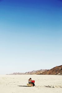 Rear view of man sitting on beach