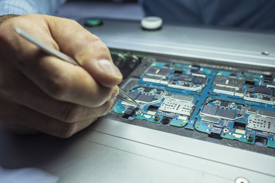 Close-up of person repairing circuit board