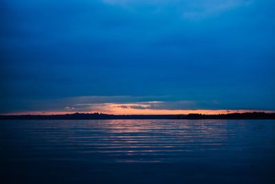 Scenic view of sea against cloudy sky during sunset