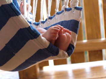 Low section of toddler boy relaxing on hammock