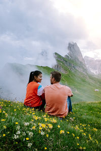 Rear view of couple on mountain against sky