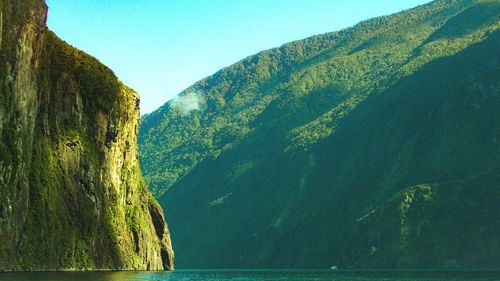 Scenic view of lake and mountains against clear sky