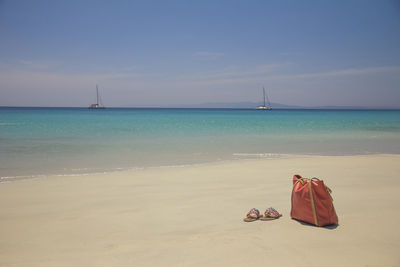 Low section of person on beach against sky