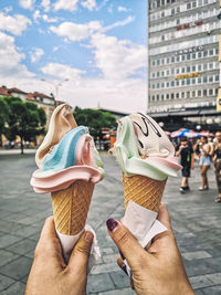 Midsection of woman holding ice cream in city