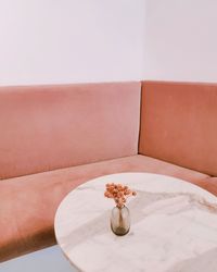 Close-up of vase on table against wall at home