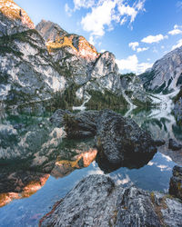 Scenic view of lake by rocks against sky