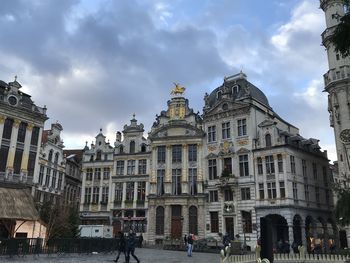 Buildings in city against cloudy sky