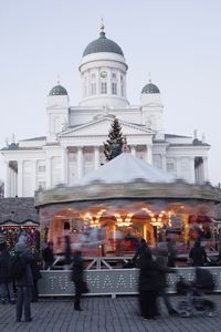 People outside temple against sky in city