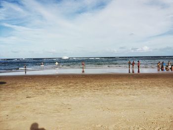 People on beach against sky