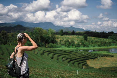 Rear view of woman standing on field