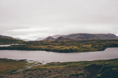 Scenic view of lake against cloudy sky