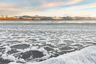 Scenic view of frozen lake against sky during sunset