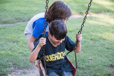 Portrait of children swinging in the park