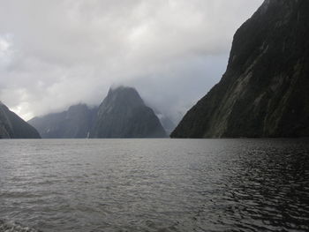 Scenic view of sea and mountains against sky